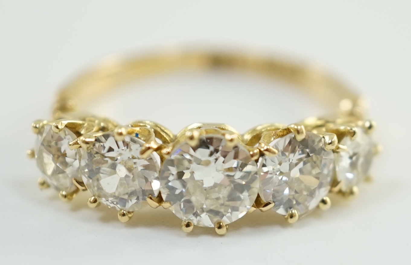 An 18ct gold and graduated five stone diamond set half hoop ring